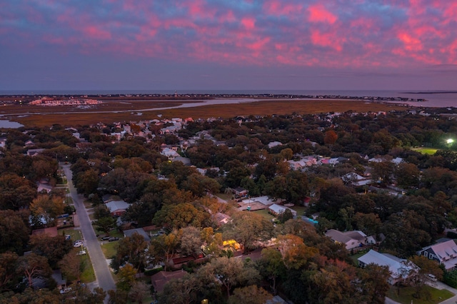 aerial view at dusk featuring a water view