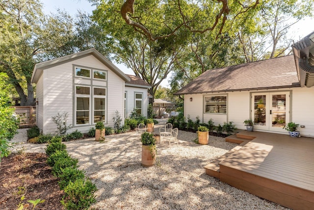 rear view of property featuring french doors and a wooden deck