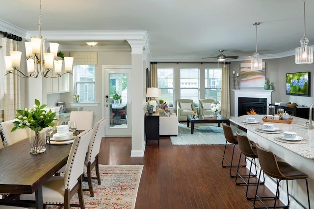 dining room with crown molding, ceiling fan with notable chandelier, and dark hardwood / wood-style floors