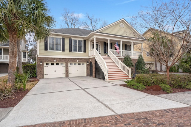 view of front of house with brick siding, stairway, covered porch, decorative driveway, and an attached garage