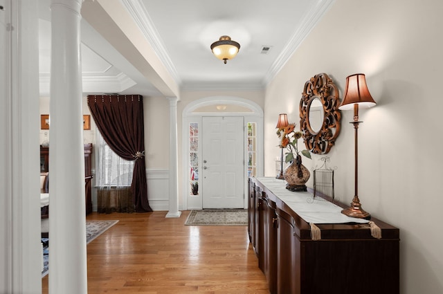 entrance foyer with decorative columns, visible vents, and ornamental molding