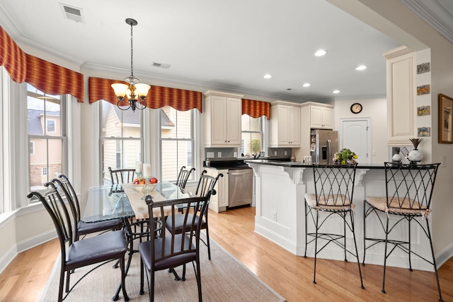 dining room featuring a wealth of natural light, visible vents, light wood-style flooring, and an inviting chandelier