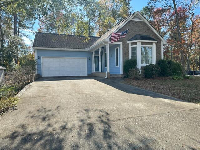 ranch-style home with concrete driveway and an attached garage