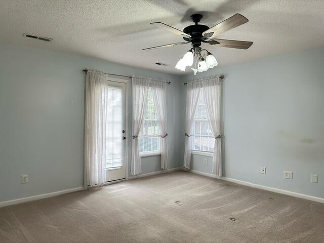 carpeted empty room featuring ceiling fan and a textured ceiling