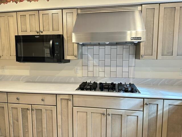 kitchen featuring gas stovetop and wall chimney range hood