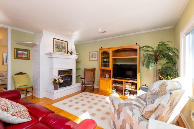 living room featuring wood-type flooring, a brick fireplace, and crown molding