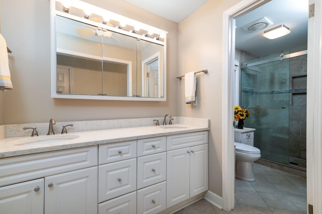 bathroom with tile patterned flooring, vanity, toilet, and a shower with door