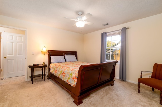 carpeted bedroom featuring ceiling fan and a textured ceiling