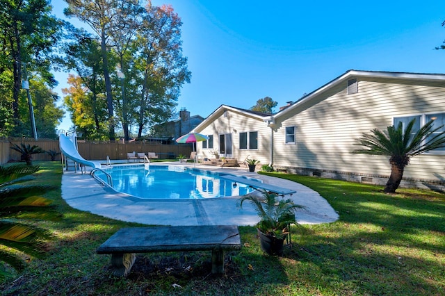 view of pool featuring a yard, a diving board, and a water slide