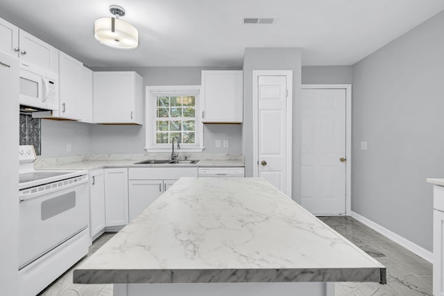 kitchen featuring a center island, white cabinetry, white appliances, and sink