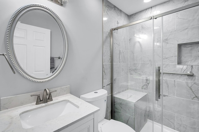 bathroom featuring vanity, toilet, and a shower with door