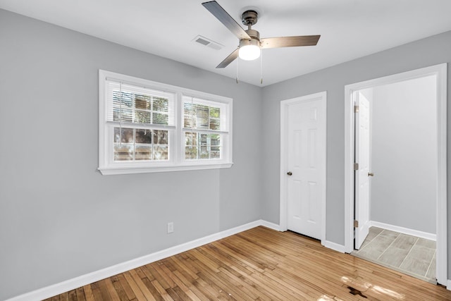 unfurnished bedroom with a closet, light hardwood / wood-style flooring, and ceiling fan