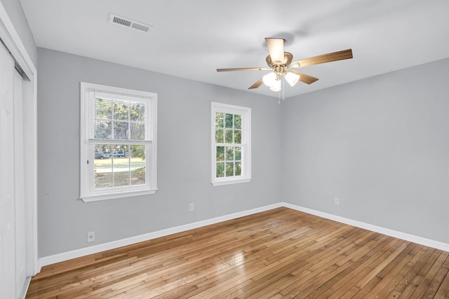 empty room with light wood-type flooring, a wealth of natural light, and ceiling fan