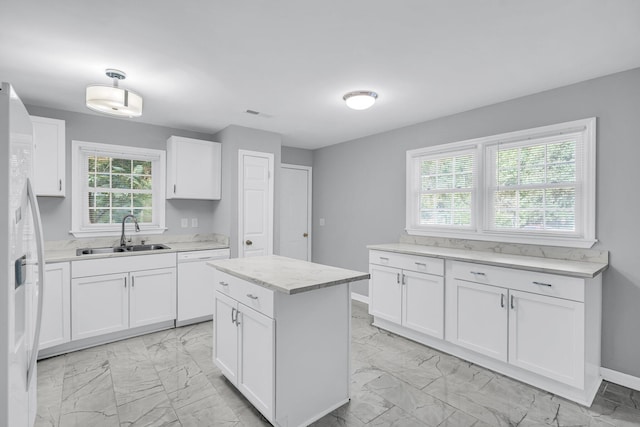 kitchen featuring a kitchen island, white cabinetry, white appliances, and sink