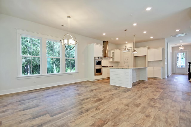 1423 Clay Field Trl, Summerville, SC 29485 - kitchen with wall chimney range hood, stainless steel double oven, baseboards, white cabinetry, and light wood finished floors