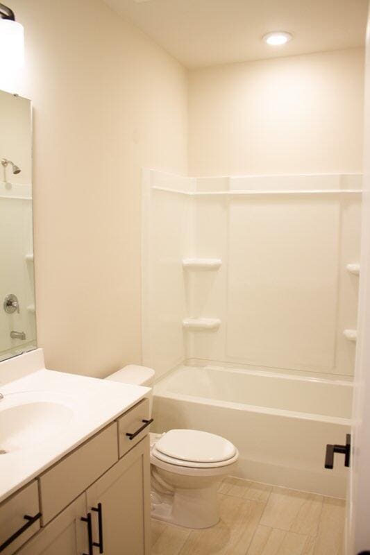 full bathroom with toilet, vanity, and  shower combination