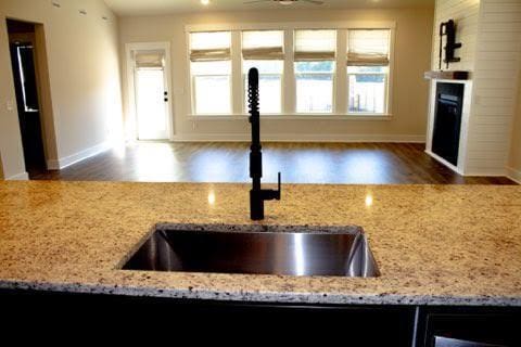 kitchen featuring light stone countertops, sink, dark hardwood / wood-style floors, and ceiling fan