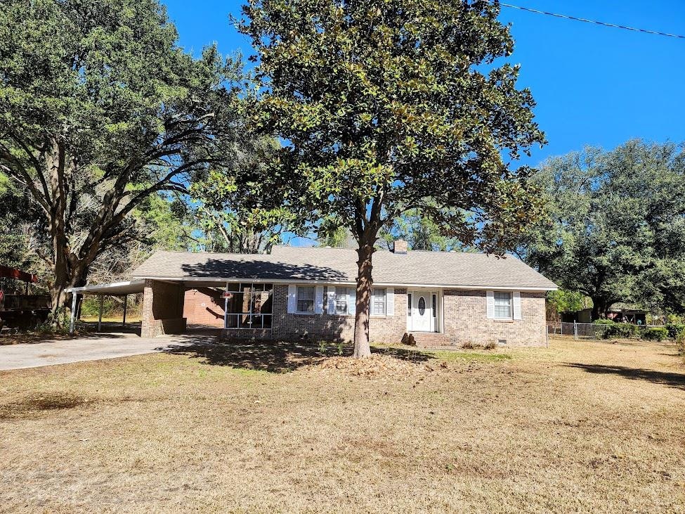 ranch-style home with a front lawn and a carport