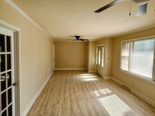 interior space with ceiling fan, a textured ceiling, light wood-type flooring, and ornamental molding