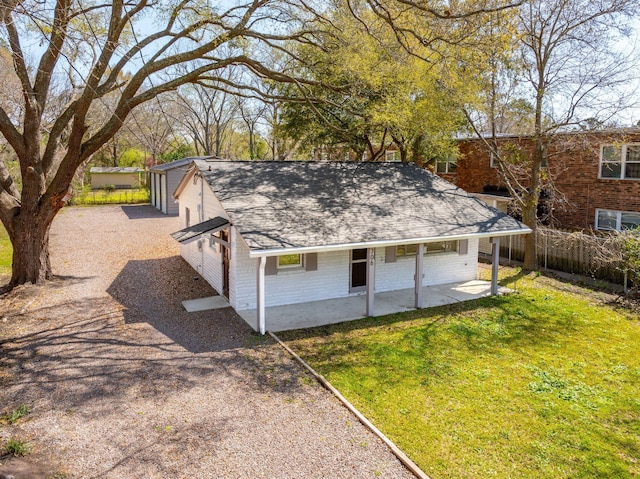 view of outdoor structure featuring fence, a porch, and gravel driveway