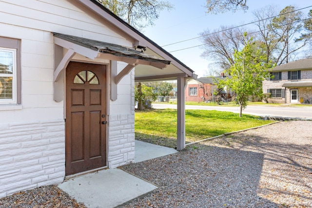 entrance to property featuring a lawn