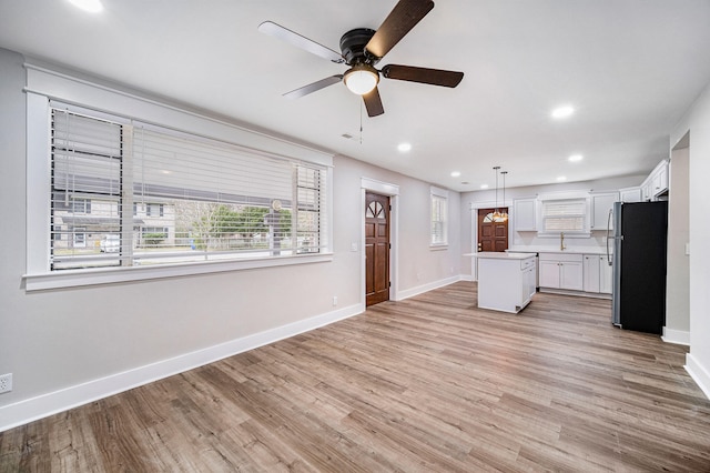 unfurnished living room with recessed lighting, ceiling fan, baseboards, and light wood-style floors