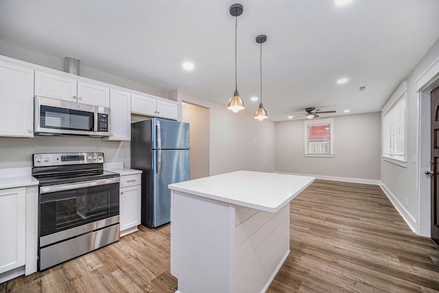 kitchen with light countertops, light wood-style flooring, white cabinets, and stainless steel appliances