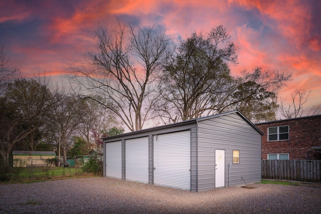 detached garage featuring fence
