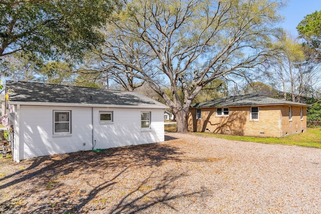 exterior space featuring roof with shingles and crawl space