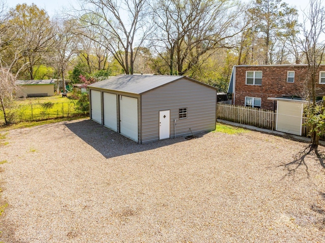 detached garage featuring fence