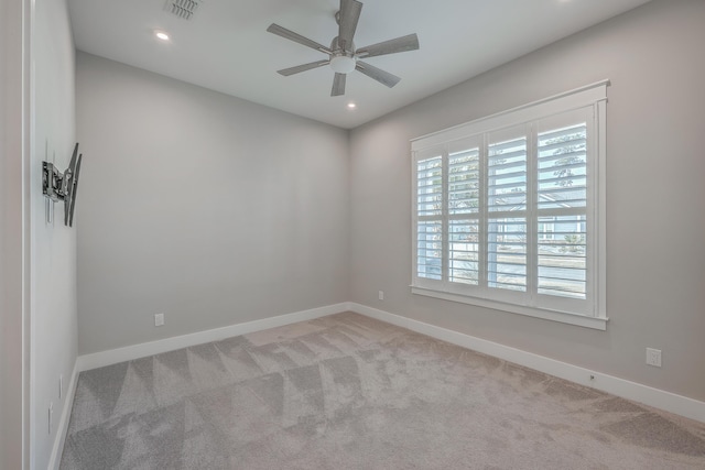 carpeted spare room featuring ceiling fan