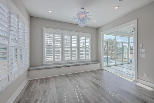 empty room featuring hardwood / wood-style floors and an inviting chandelier