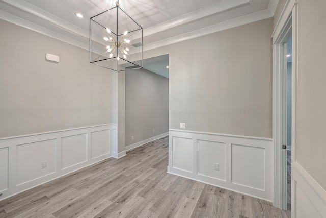 unfurnished dining area featuring crown molding, a notable chandelier, and light hardwood / wood-style flooring