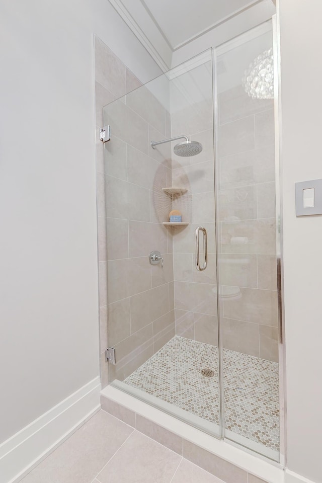 bathroom with tile patterned flooring, ornamental molding, and walk in shower