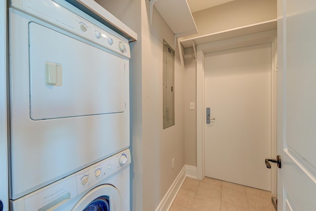 laundry area with light tile patterned floors, stacked washer and dryer, and electric panel