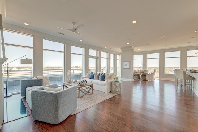 living room with hardwood / wood-style flooring, ceiling fan, and a water view