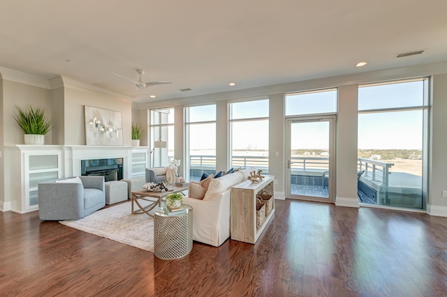 living room featuring ceiling fan, dark hardwood / wood-style floors, and ornamental molding