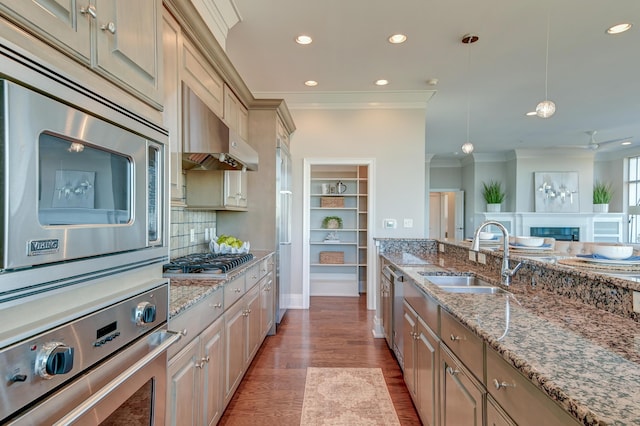 kitchen with pendant lighting, backsplash, crown molding, sink, and appliances with stainless steel finishes