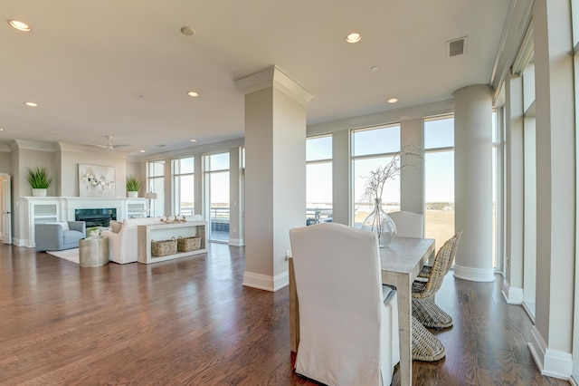 dining room featuring a wealth of natural light, crown molding, and dark wood-type flooring