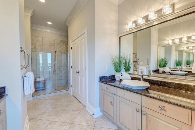 bathroom featuring tile patterned floors, vanity, a shower with shower door, and ornamental molding