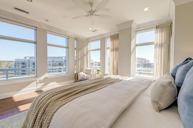 bedroom with hardwood / wood-style flooring, ceiling fan, and ornamental molding