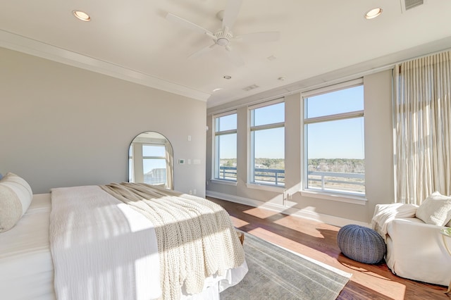 bedroom featuring hardwood / wood-style flooring, ceiling fan, and ornamental molding