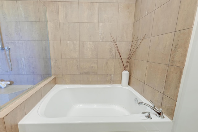 bathroom featuring a tub to relax in and tile walls