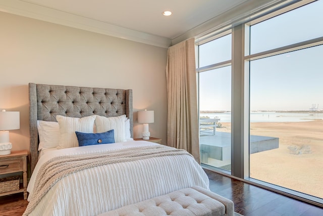 bedroom with access to exterior, a water view, hardwood / wood-style flooring, and ornamental molding