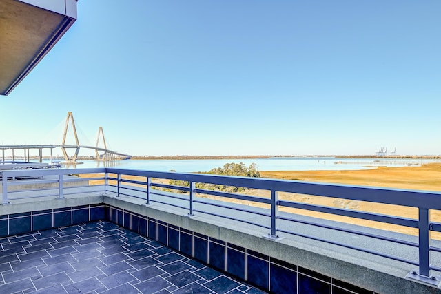 view of patio / terrace with a balcony and a water view