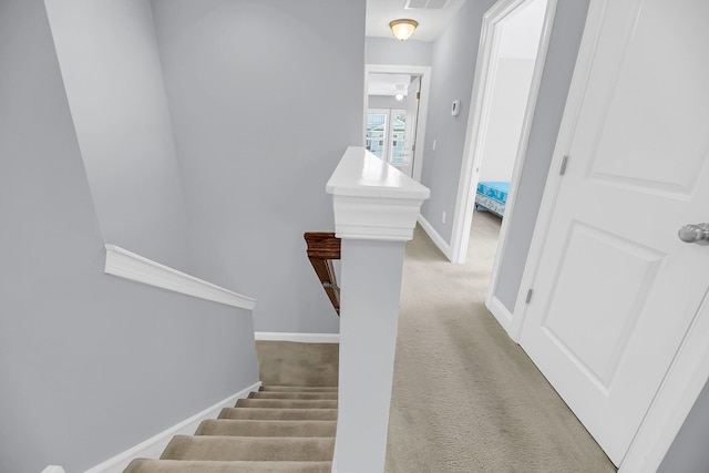 stairs with carpet flooring, visible vents, and baseboards