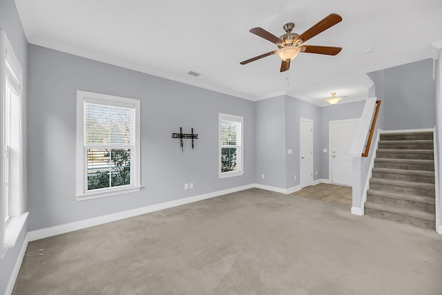 spare room featuring light colored carpet, visible vents, ornamental molding, baseboards, and stairs