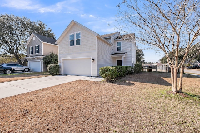 traditional-style home with a garage, concrete driveway, and fence