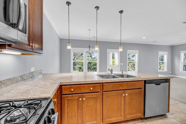 kitchen featuring a wealth of natural light, appliances with stainless steel finishes, brown cabinetry, and a sink