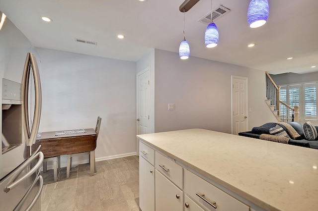 kitchen with decorative light fixtures, white cabinetry, visible vents, and stainless steel fridge with ice dispenser